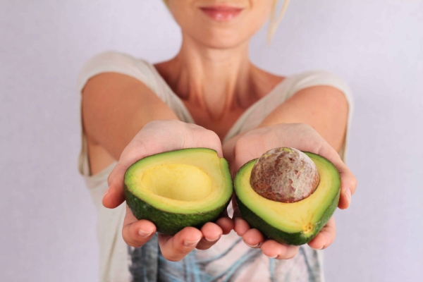 woman holding avocados