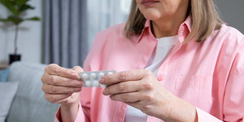 Woman holding pack of pills