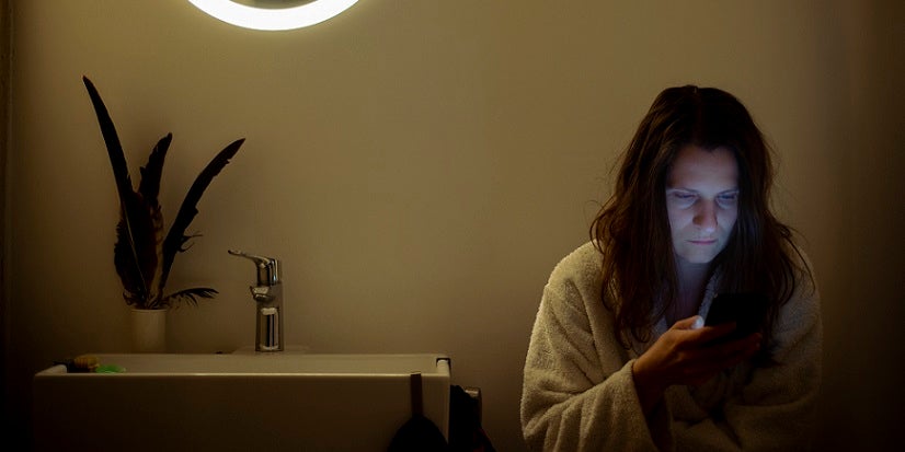 Women scrolling her phone on toilet