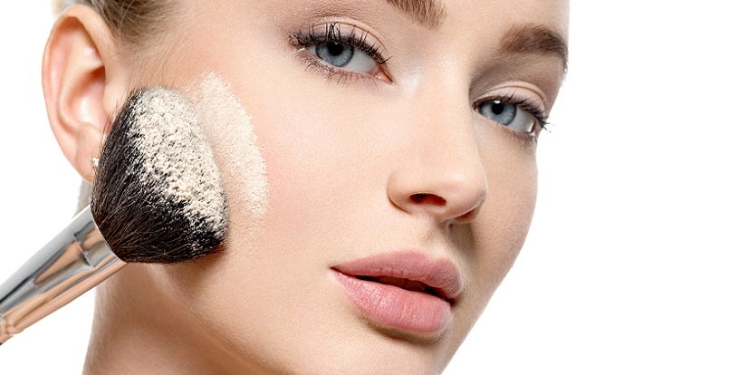 Woman putting powder on face