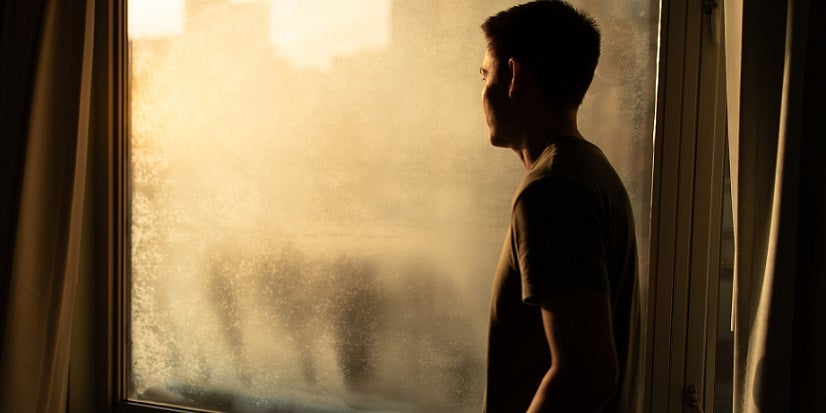 Man looking out window