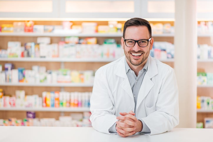 Pharmacist with medications in background