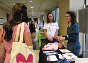 BRG Occupational and Physical Therapists Trisha Smith and Angie Netterville explain the benefits of infant massage to Bloom attendees.